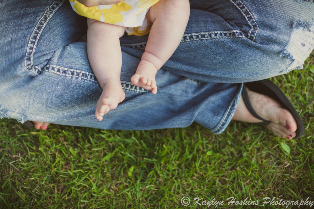 baby sits in mom's lap shown by their toes