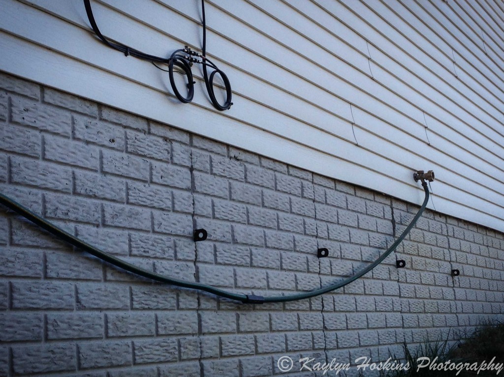 Smiley Face on side of house with hose