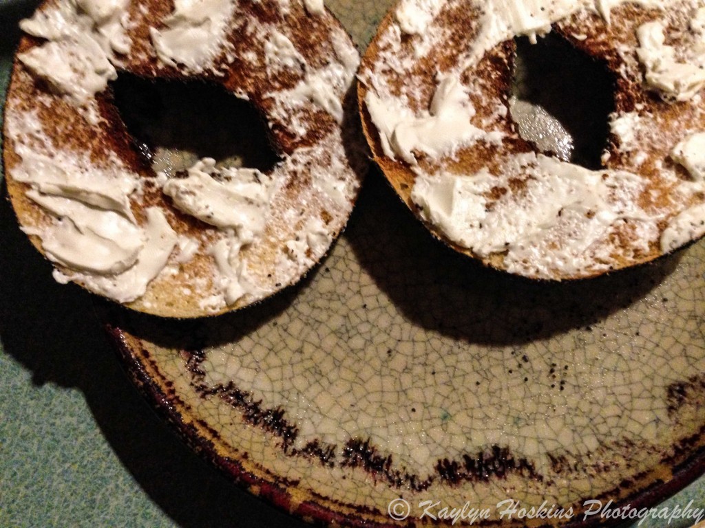 Toasted open bagel on plate makes smiley face